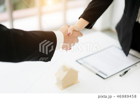 Real estate broker and customer shaking hands 46989458
