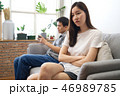 Girl sitting on sofa is feeling bored with friend 46989785