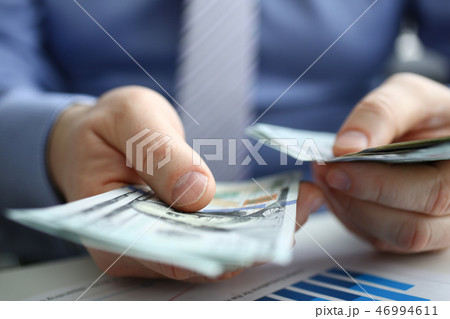 The businessman considers cash dollars in the office The businessman considers cash dollars in the office 46994611