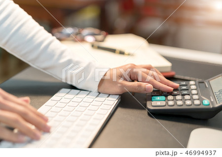 business women typing on calculator at office 46994937