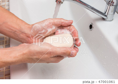 Washing hands with soap in the sink 47001061