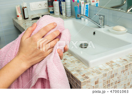 Man wipes his hands with a towel in the bathroom, close-up 47001063