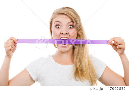 Attractive blonde woman biting tape on mouth. Attractive blonde woman biting tape on mouth. 47002832