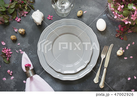 Easter table setting with pink flowers on dark. 47002926