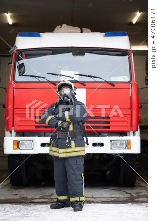 Full-length photo of man fireman in gas mask near fire truck Full-length photo of man fireman in gas mask near fire truck 47006171