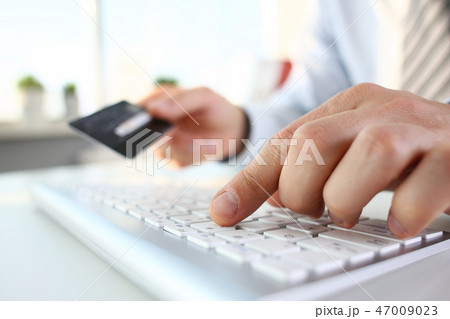 Male arms hold credit card press buttons Male arms hold credit card press buttons 47009023