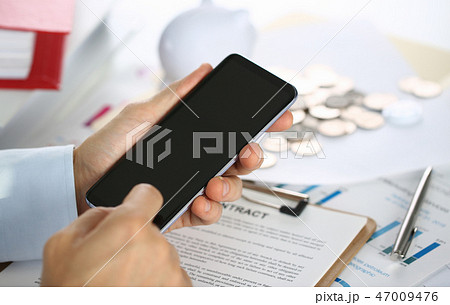 A businessman holds a new smartphone A businessman holds a new smartphone 47009476