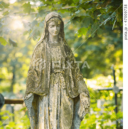 Statue of Mary Mother of God, at autumn tree backgroung. Religious symbol. 47009738