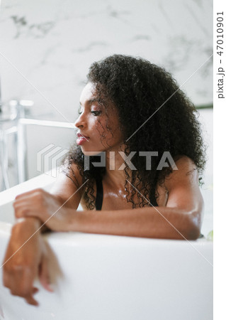Young brown skin girl lying in barth and wearing black underwear. 47010901