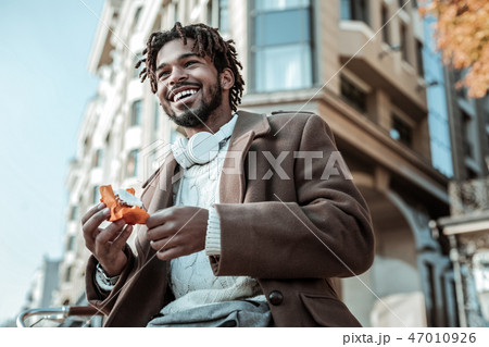 Delighted brunette male enjoying walk in city center Delighted brunette male enjoying walk in city center 47010926