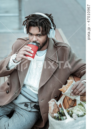Relaxed young international man drinking hot coffee 47010967