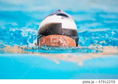 Man swimming in blue pool water Man swimming in blue pool water 47012259