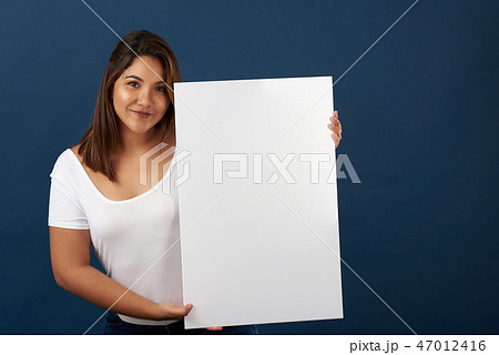 Pretty hispanic woman with white big banner Pretty hispanic woman with white big banner 47012416