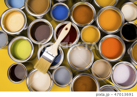 Tin cans with paint and brushes, yellow background Tin cans with paint and brushes, yellow background 47013691