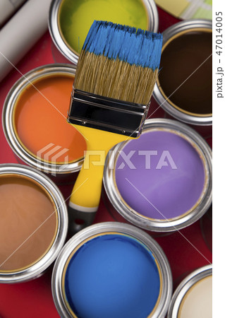 Can with paint and paintbrush, red background Can with paint and paintbrush, red background 47014005