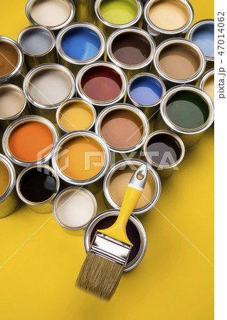 Paint can with a paintbrush, yellow background Paint can with a paintbrush, yellow background 47014062