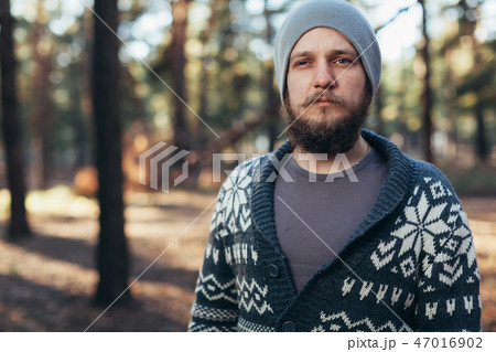a young man with a beard walks in a pine forest. a young man with a beard walks in a pine forest. 47016902