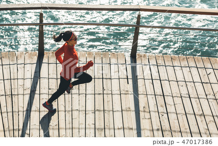 fitness woman runner running on seaside boardwalk 47017386
