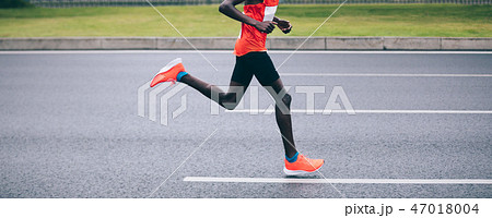 Marathon runner legs running on city road Marathon runner legs running on city road 47018004