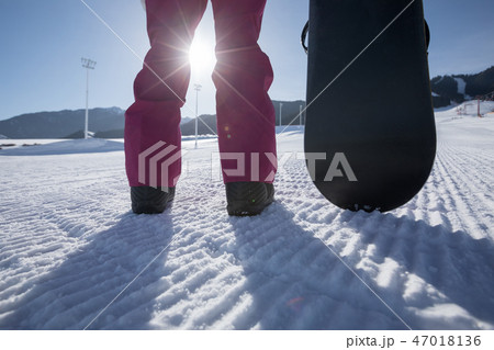 snowboarder with snowboard stand on ski piste  47018136