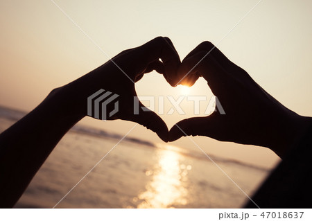Sunset shining through heart shaped hands 47018637