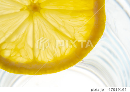 Lemon slice backlit in a glass of water 47019165