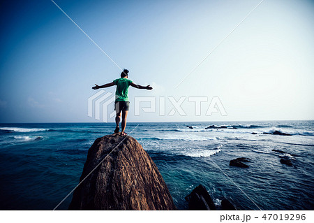 walking on seaside cliff edge with arms opened walking on seaside cliff edge with arms opened 47019296