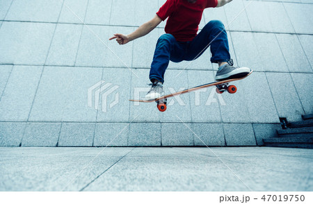 Skateboarder doing ollie at city 47019750