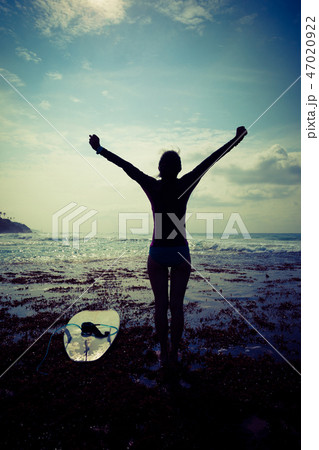 Woman surfer open arms on seaside Woman surfer open arms on seaside 47020922