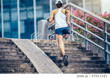 woman runner sportswoman running up city stairs 47021581