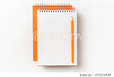 Top view of orange spiral notebook, page, pencil 47025998