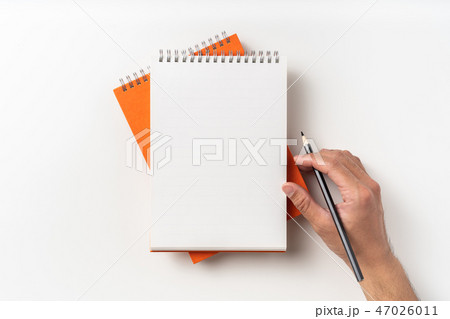 Top view of orange spiral notebook, page, pencil 47026011