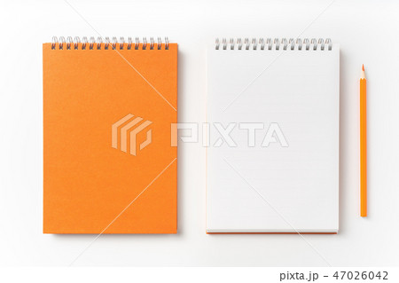 Top view of orange spiral notebook, page, pencil 47026042