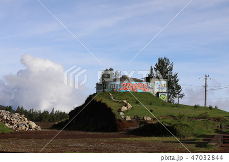 Building stands on high ground and painted with multicolored cans 47032844
