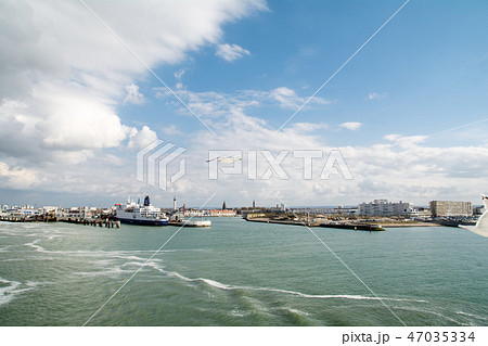 フランスのカレーの港を離れるフェリーから見たフェリーふ頭と空を優雅に飛ぶカモメ 47035334