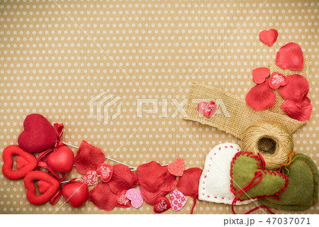 Many red hearts lie on an old cardboard background in white peas. Many red hearts lie on an old cardboard background in white peas. 47037071
