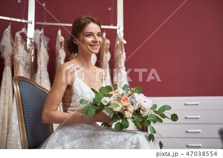 Charming bride in wedding dress with flowers Charming bride in wedding dress with flowers 47038554