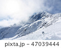 Snowy mountains peak and skies with clouds 47039444