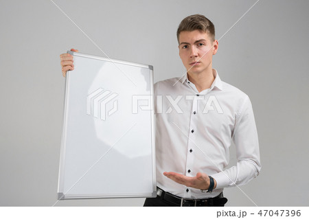 Portrait of young man with clean magnetic Board in his hands isolated on white background Portrait of young man with clean magnetic Board in his hands isolated on white background 47047396