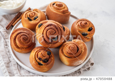 Freshly Baked Traditional Sweet Cinnamon Rolls, Swirl on white plate. Copy space. 47050488