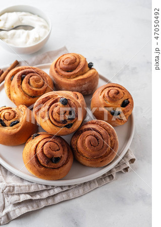 Freshly Baked Traditional Sweet Cinnamon Rolls, Swirl on white plate. Copy space. 47050492