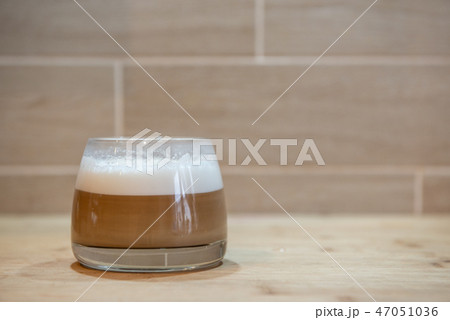 multilayer coffee or cappuccino in a glass cup on wooden table 47051036