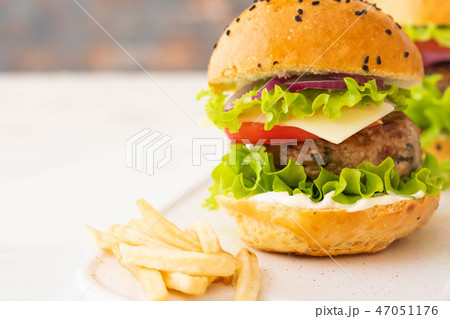 Delicious burgers with beef, tomato, cheese, french fries and lettuce. Copy space. 47051176