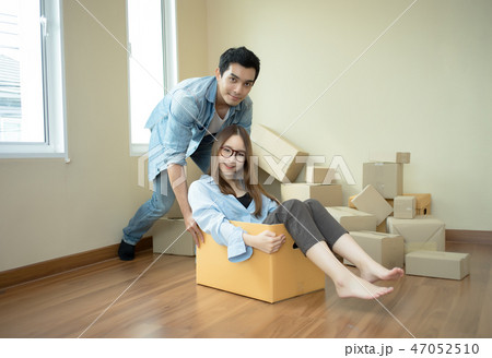 Happy couple having fun young pushing on cardboard 47052510