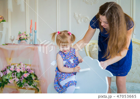Little girl playing on wooden rocking horse Little girl playing on wooden rocking horse 47053665