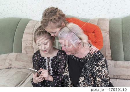 Grandchildren teach great-grandmother to use smartphone Grandchildren teach great-grandmother to use smartphone 47059119