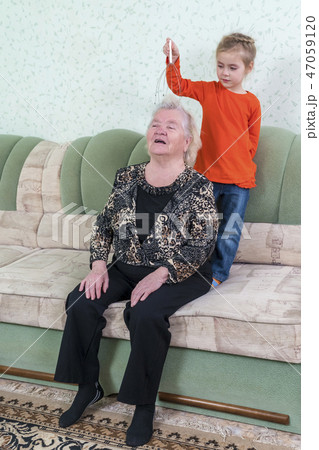 granddaughter massages grandmother head granddaughter massages grandmother head 47059120