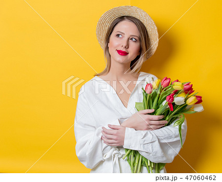 woman in white shirt and hat with fresh springtime tulips woman in white shirt and hat with fresh springtime tulips 47060462
