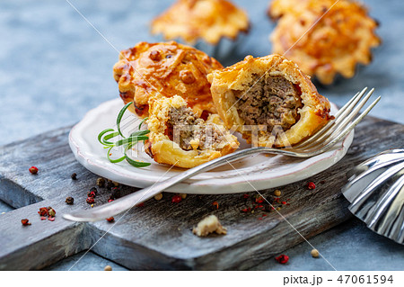 Mini pies stuffed with meat. 47061594