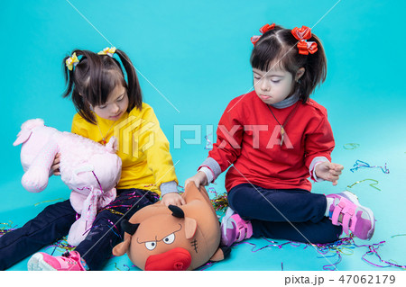 Appealing twins spending time together with plush toy 47062179